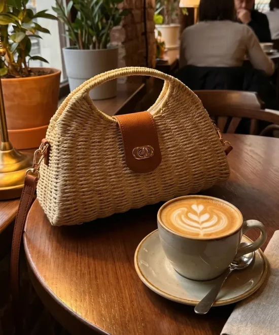 Bolso de rafia de mano y bandolera de mujer sobre mesa
