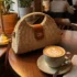 Bolso de rafia de mano y bandolera de mujer sobre mesa
