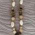 collar de piedras nacadas en blanco y marron y beige encima de un paño