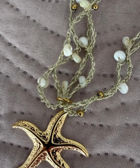 collar de estrella sobre un paño en colores dorados y verde agua