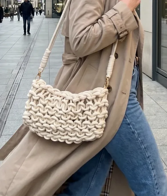 Bolso bandolera de nudo macrame estilo boho de mujer caminando por la calle con ropa de mirishop