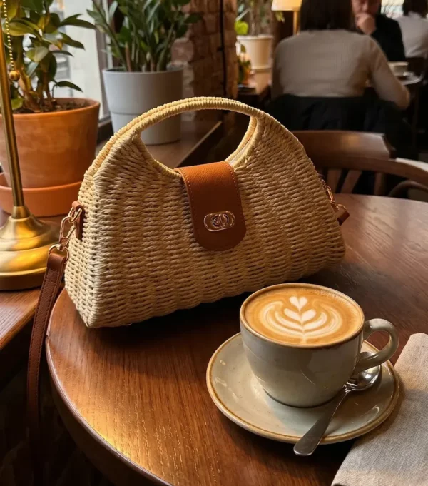 Bolso de rafia de mano y bandolera de mujer sobre mesa