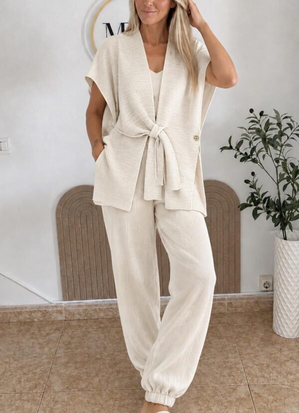 mujer rubia posando en la pared con un conjunto beige de mirishop