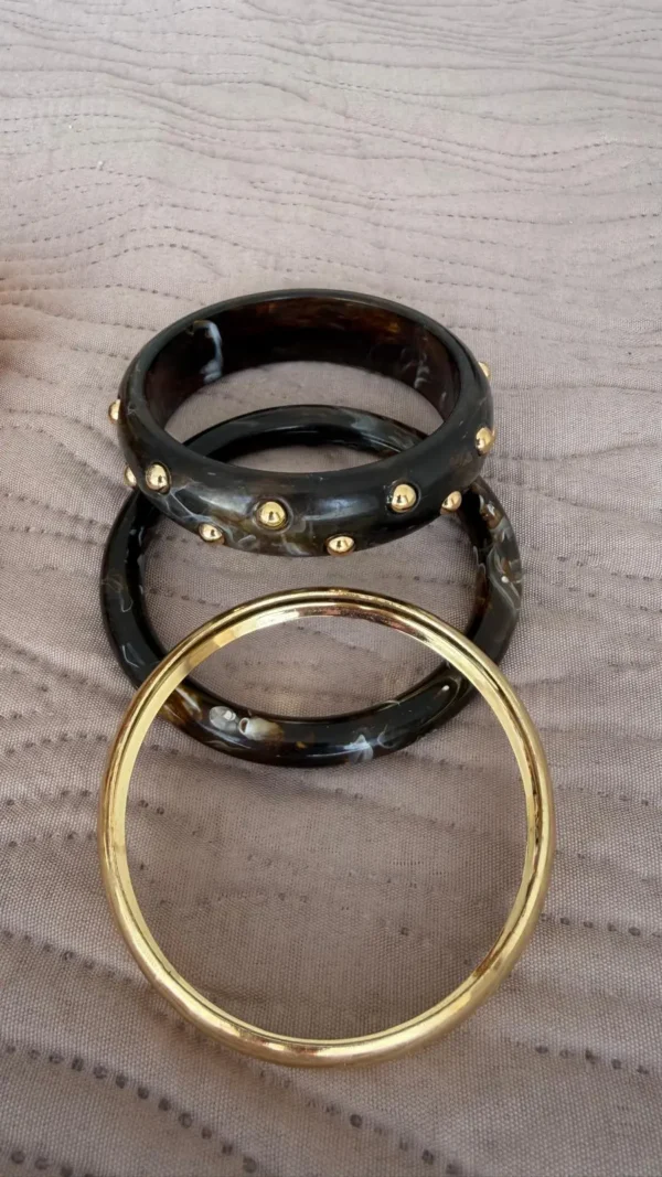 pulseras brazaletes con efecto marmol con detalles dorados en un paño