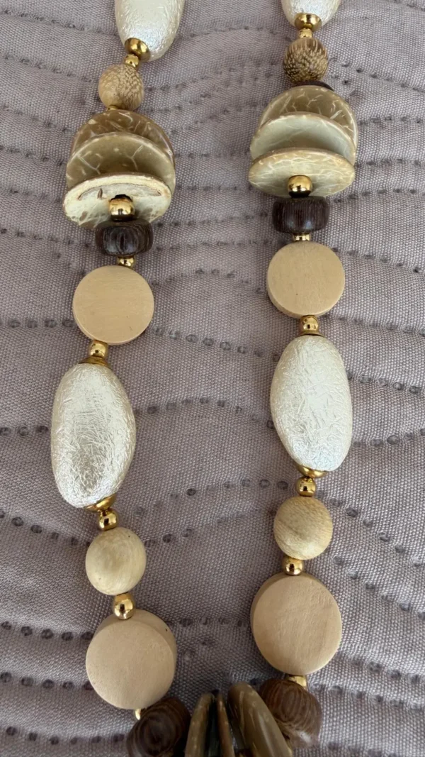 collar de piedras nacadas en blanco y marron y beige encima de un paño